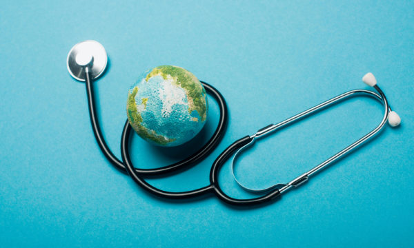 Globe and stethoscope on blue background, world health day concept