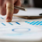 Male arm point finger at important paper on table in office closeup. Paperwork job trade balance bank credit loan money invest payment irs commerce partnership man in suit concept