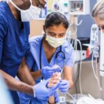 diverse emergency room team works on unrecognizable patient