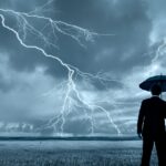 Man in black suit with a black umbrella in a storm