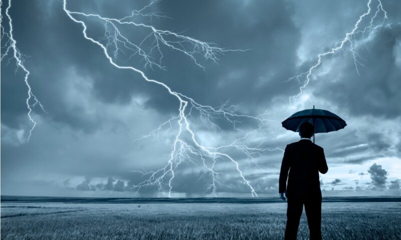 Man in black suit with a black umbrella in a storm