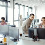 oung AI programmers and IT software developers team brainstorming and programming on desktop computer in startup company share office space