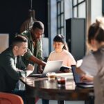 Young professionals or students collaborating in a bright, contemporary co-working environment, displaying teamwork and productivity.