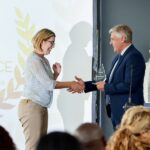 Shot of a young businesswoman being awarded a prize during an awards giving ceremony at a conference