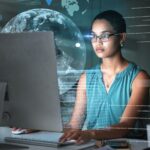 Computer, Earth data hologram and woman reading finance chart, stock market database or futuristic night overlay. Forex investment, global ecommerce and African trader trading NFT, bitcoin or crypto