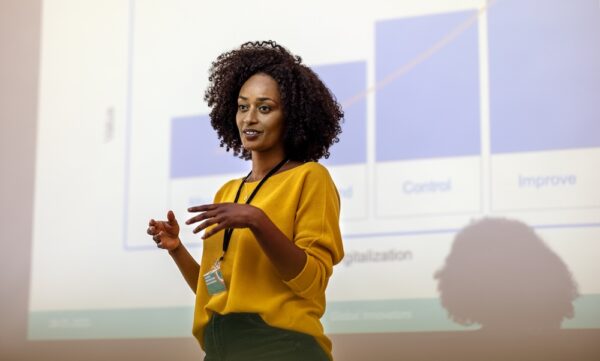 Woman entrepreneur speaking in the auditorium at the corporate training event. Woman at seminar giving a presentation.