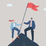 Strong teamwork leading to success for organizations, business people working as a team or partners helping to raise the flag of victory on the top of the highest mountain.