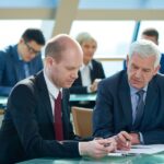 Two serious men looking at document