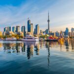 Toronto, Canada city skyline and tower on Lake Ontario at dawn.