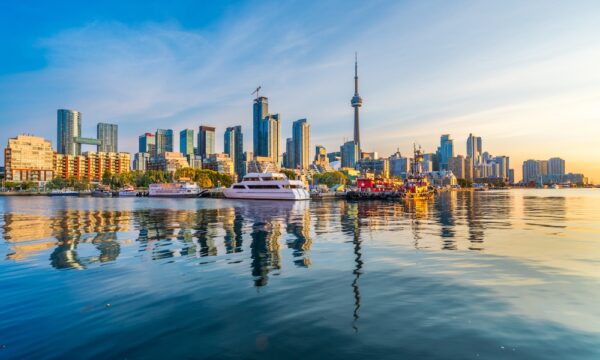 Toronto, Canada city skyline and tower on Lake Ontario at dawn.