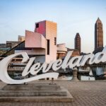 In Ohio the Cleveland script sign is placed in front of the cityscape with the Rock and Roll Hall of Fame building.