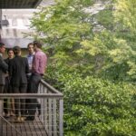 Confident business colleagues discussing on balcony at office. Male and female executives are planning strategy outdoors. They are wearing formals.