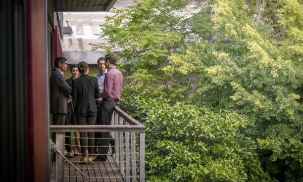 Confident business colleagues discussing on balcony at office. Male and female executives are planning strategy outdoors. They are wearing formals.