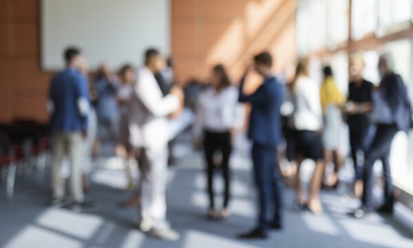 A blurred image of a group of business people attending a meeting