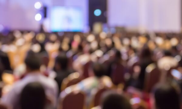 Blur audience sitting in hall or auditorium or classroom