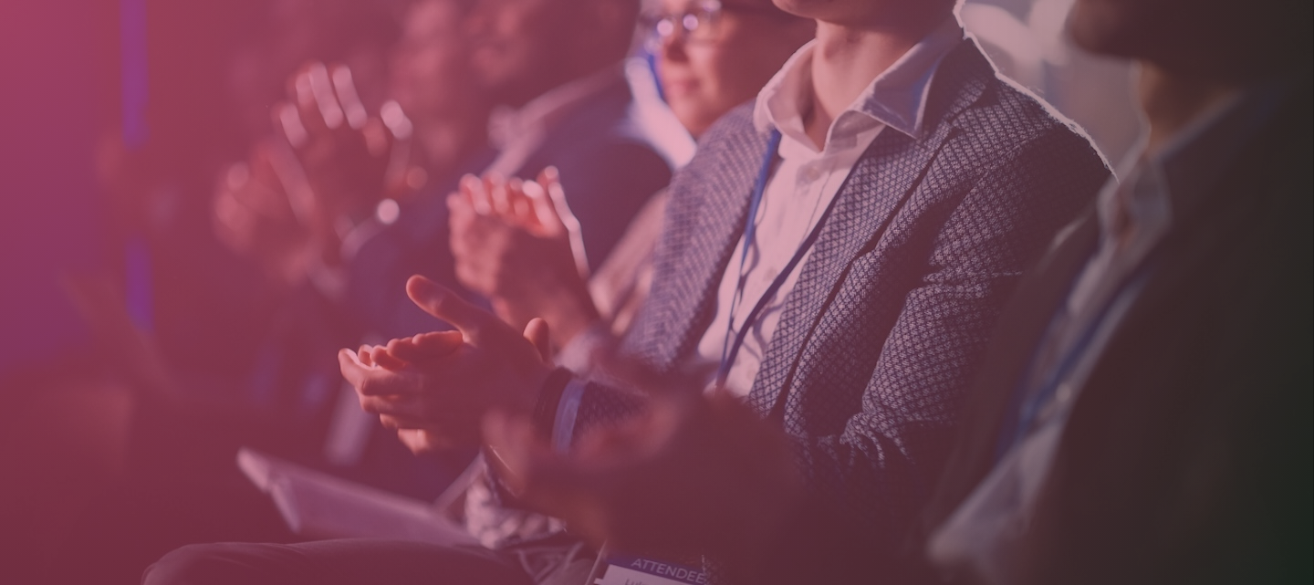 Close Up on Hands of a Crowd of People Clapping in Dark Conference Hall During a Motivational Keynote Presentation