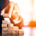 plan and strategy in business.risk concept.hand of man has piling up and stacking a wooden block.Businessman Building The Success.