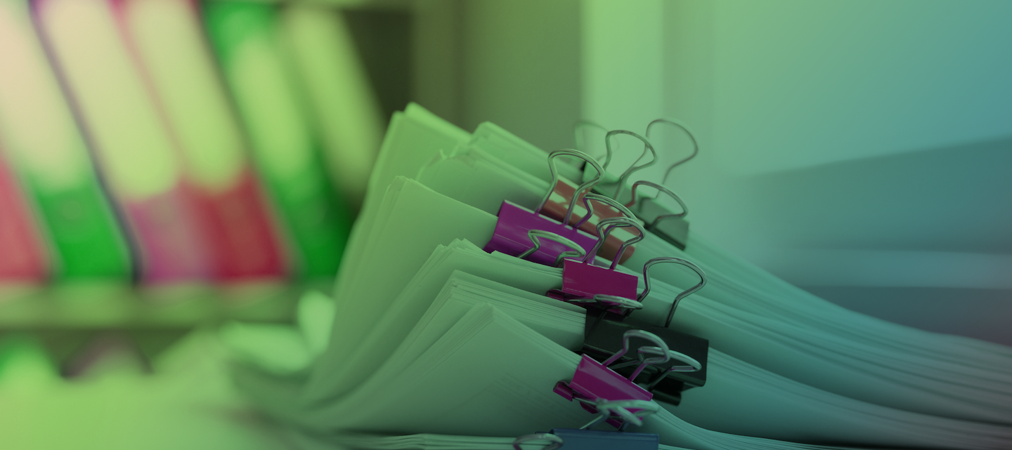 Stack of report paper files in business office clipped with clips