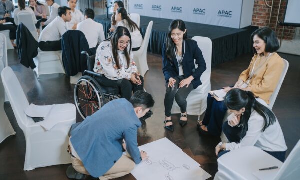 Team building Asian workshop participants in small group discussion, brainstorming during business workshop class